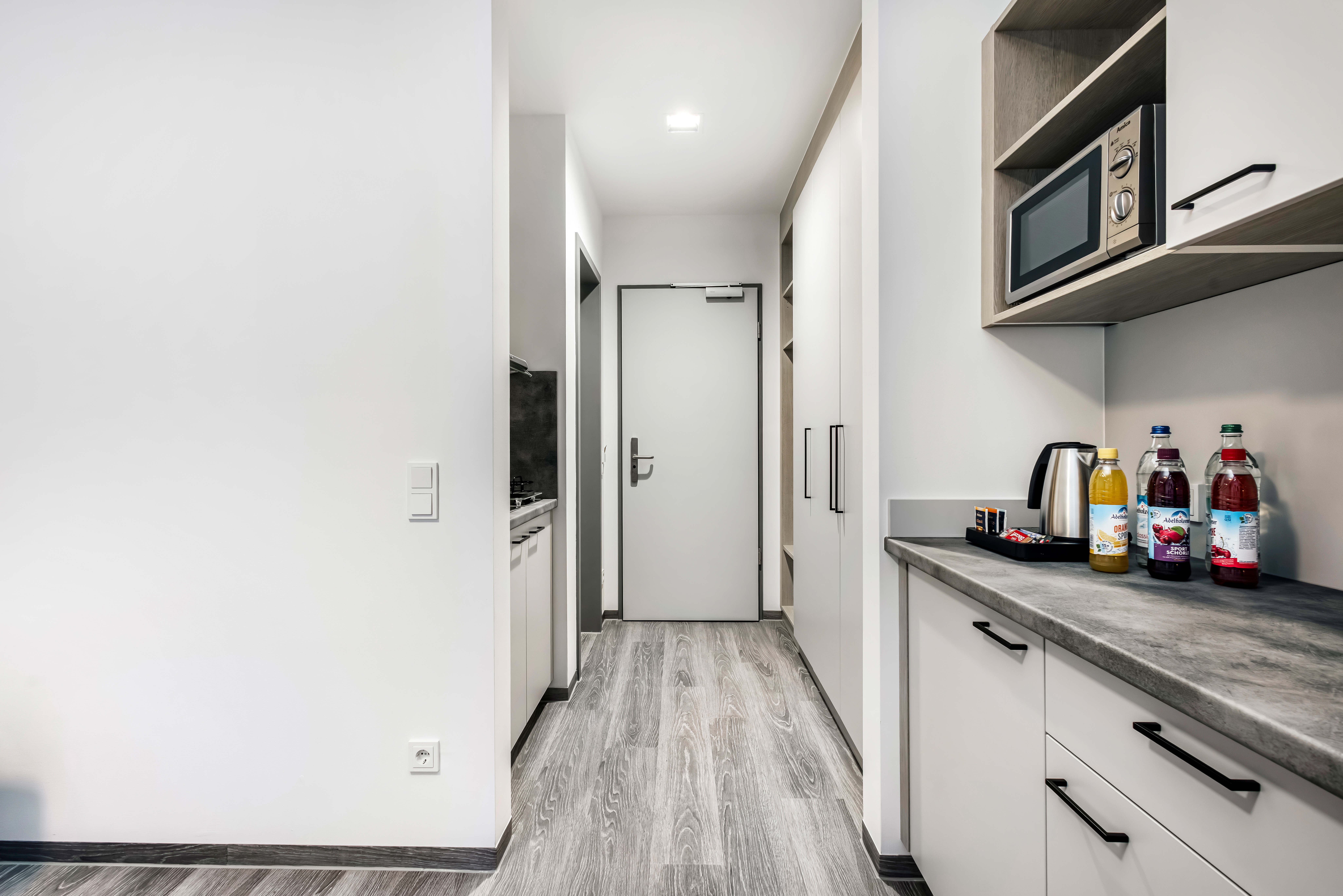 Hotelzimmer mit Küchenzeile, Kühlschrank und Mikrowelle.