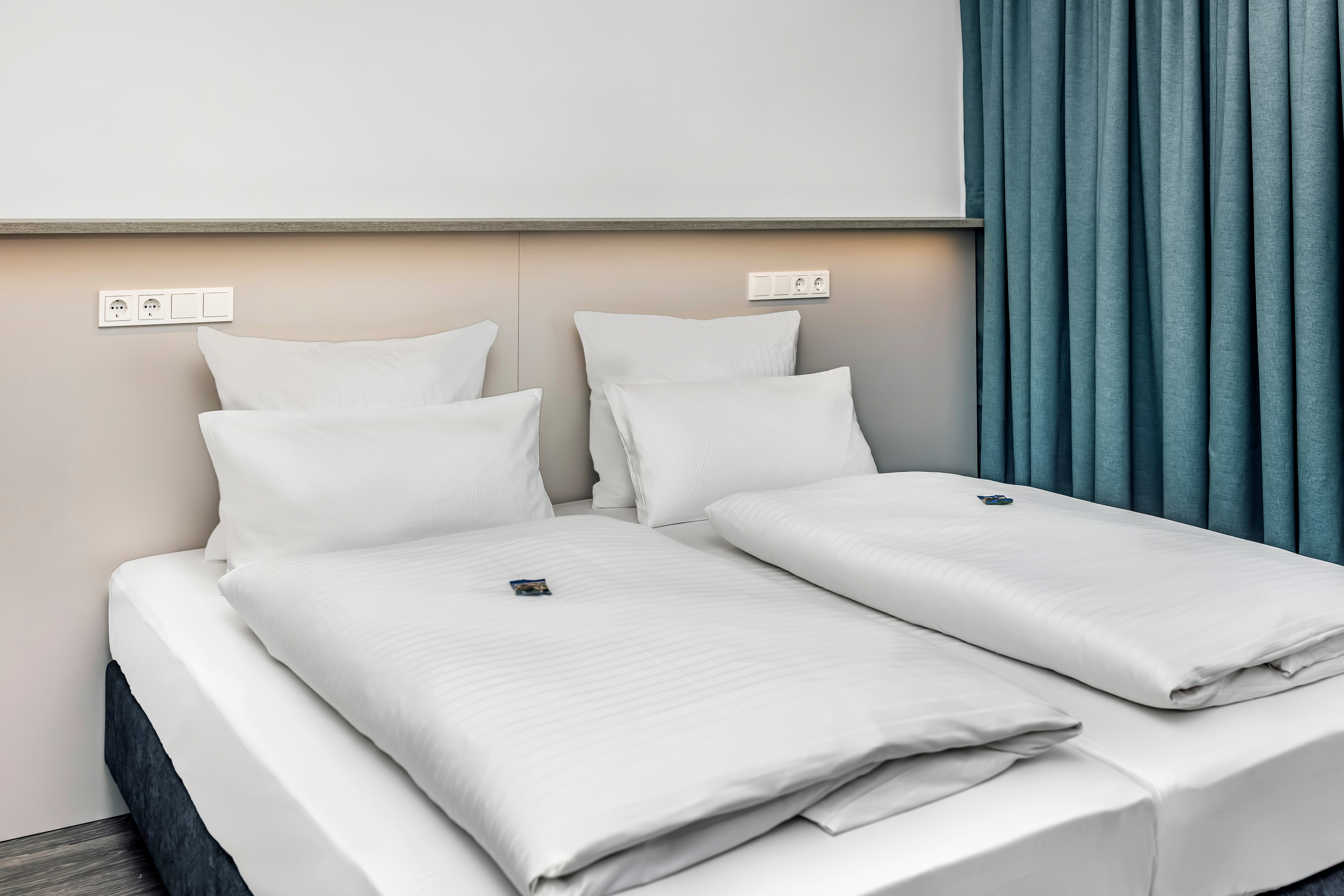 Elegantes Hotelzimmer mit Doppelbett und Vorhängen