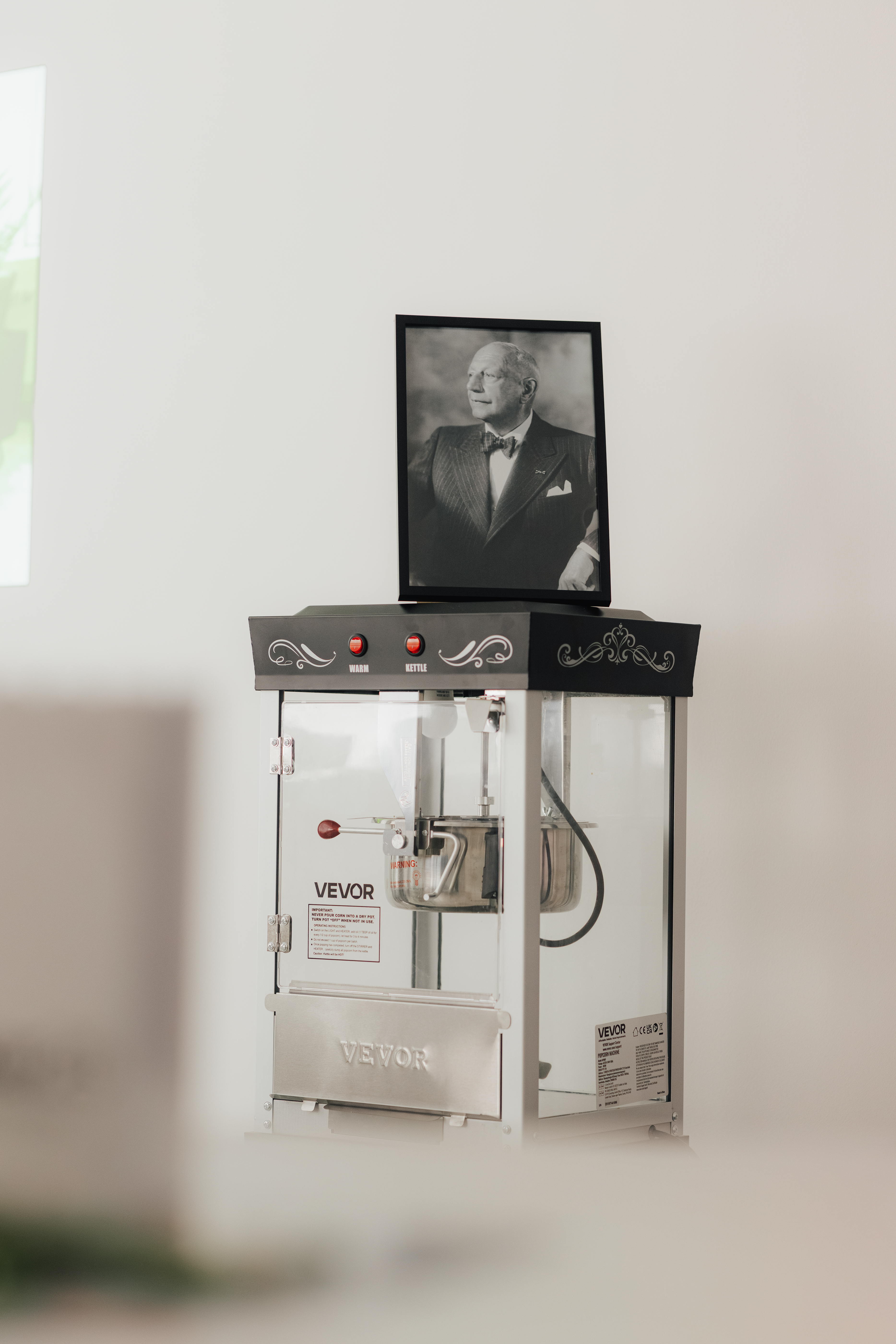 Popcornmaschine mit einem Portrait eines Mannes im Hintergrund.
