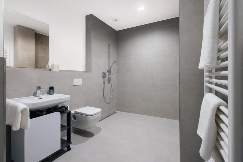 Modernes Hotelzimmer mit Dusche und Waschbecken.