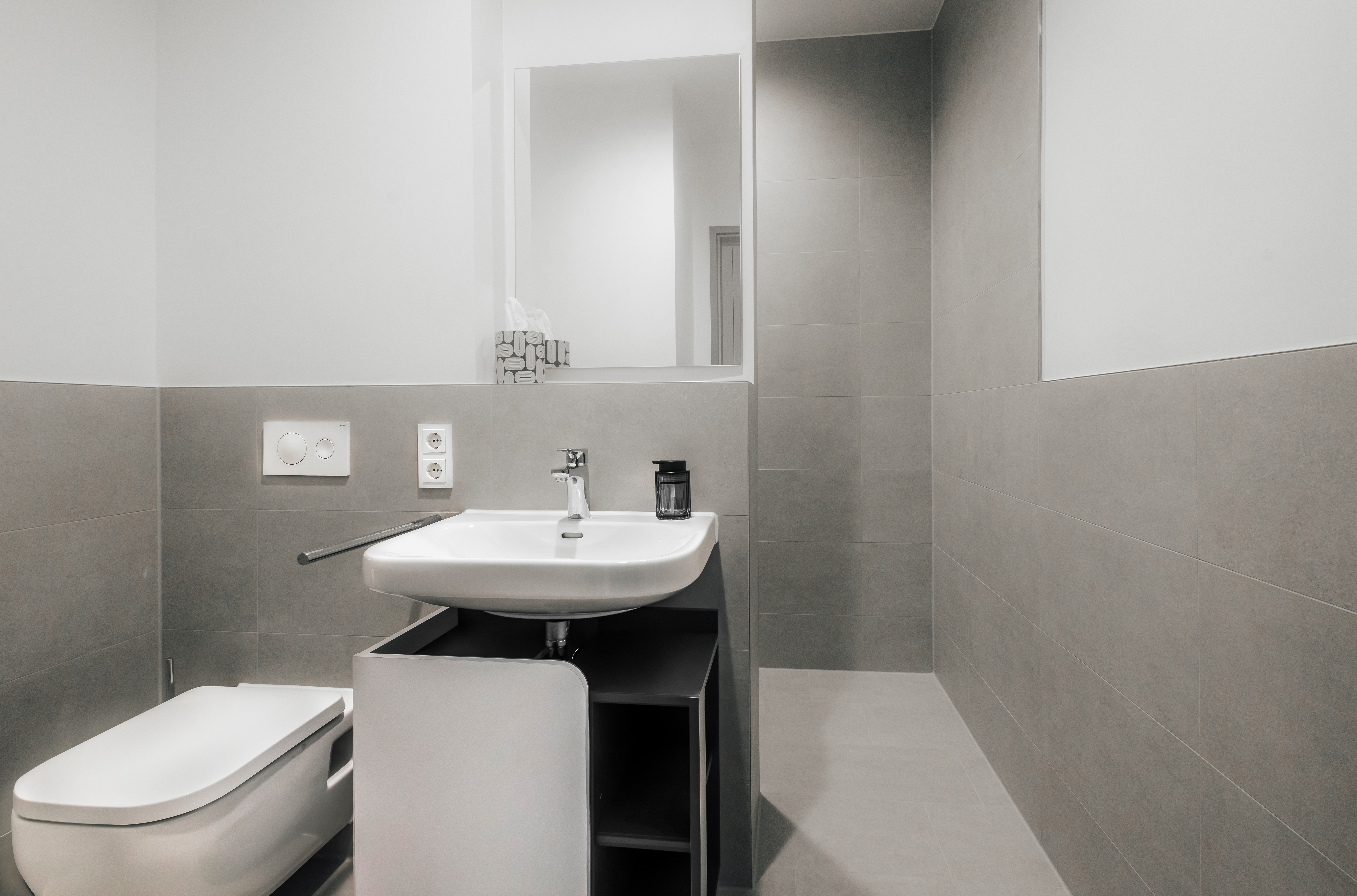 Modernes Badezimmer mit Dusche und Waschbecken im Hotel.