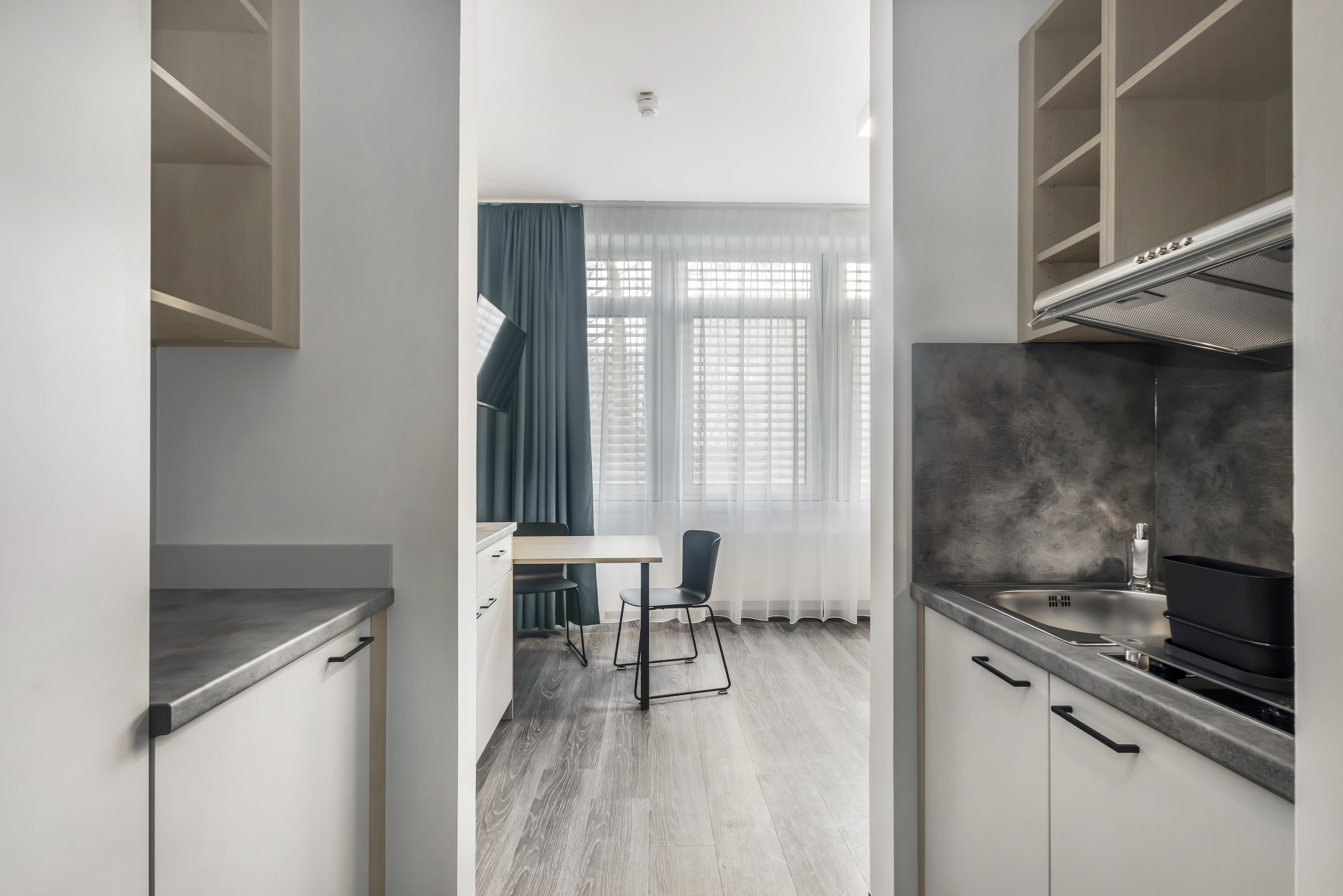 Ein modernes Hotelzimmer mit Küche und Schreibtisch.