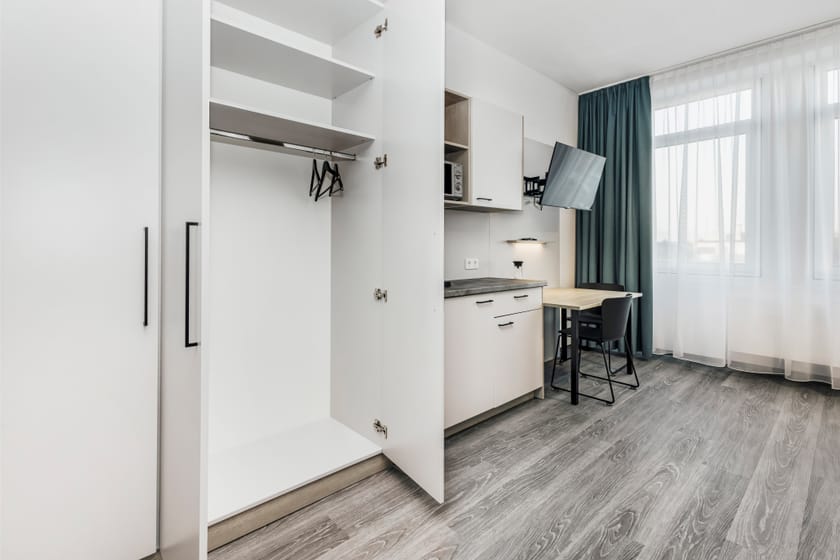 Modernes Hotelzimmer mit Schreibtisch und Kleiderschrank.