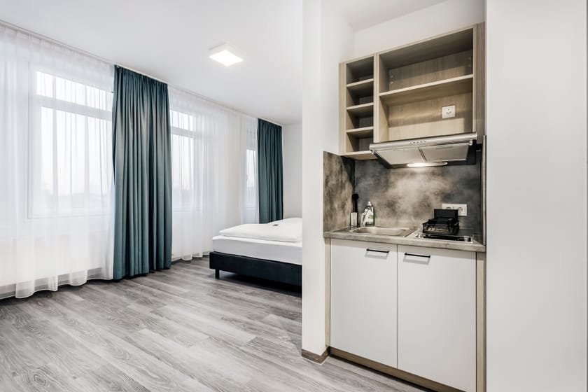 Modernes Hotelzimmer mit Kochnische und Fensterblick.