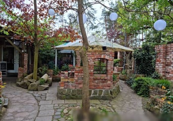 Ein Garten mit einer Laube und gepflasterten Wegen.