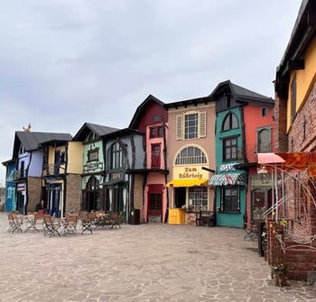 Bunte Gebäude und Cafés in einem malerischen Dorf.