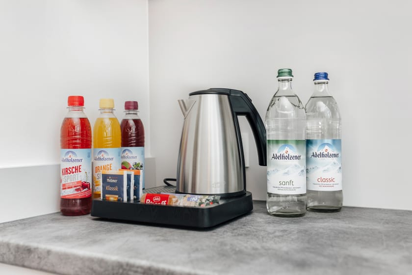 Wasserkocher und verschiedene Getränke in einem Hotelzimmer.