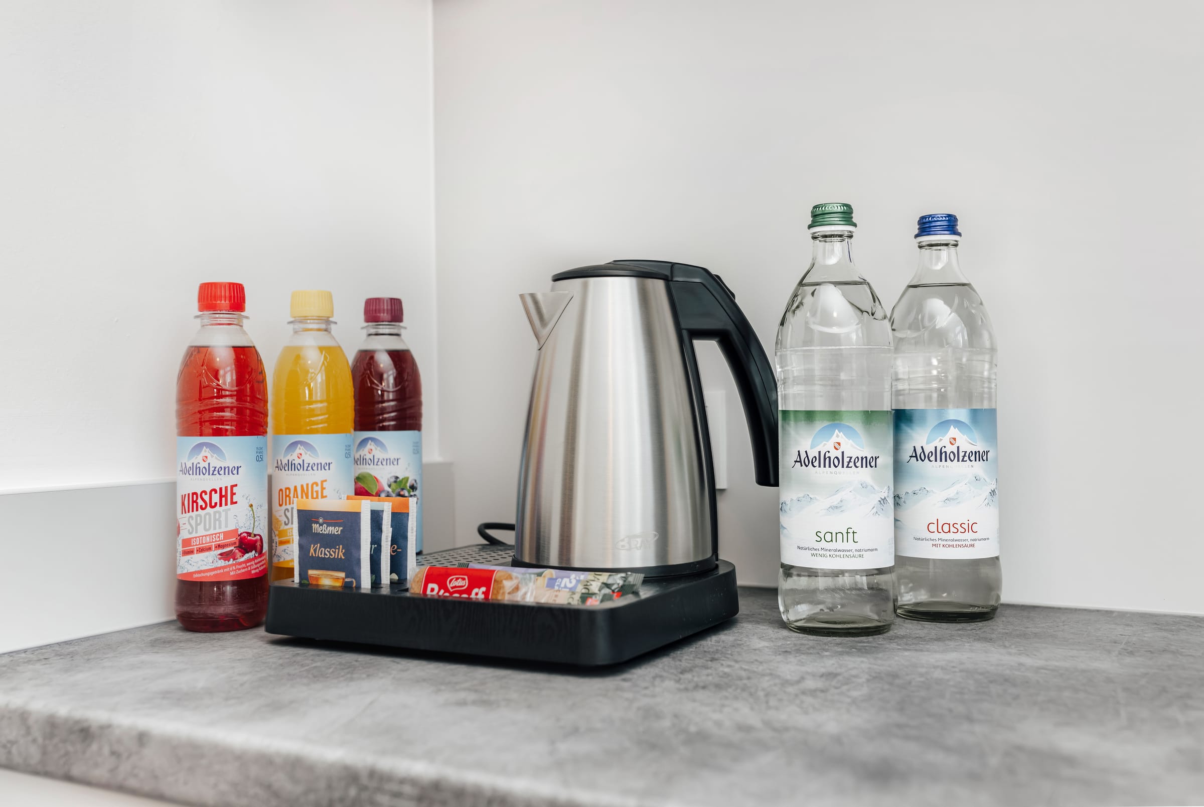 Wasserkocher und verschiedene Getränke in einem Hotelzimmer.