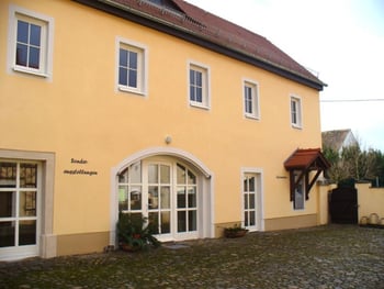Fassade der Touristinformation Schmannewitz mit gelber Wandfarbe.