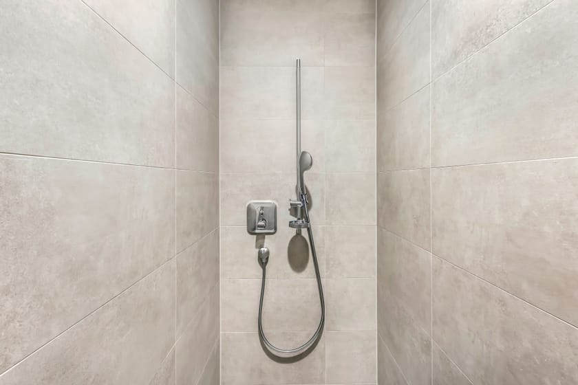 Moderne Dusche mit grauen Fliesen und Handbrause